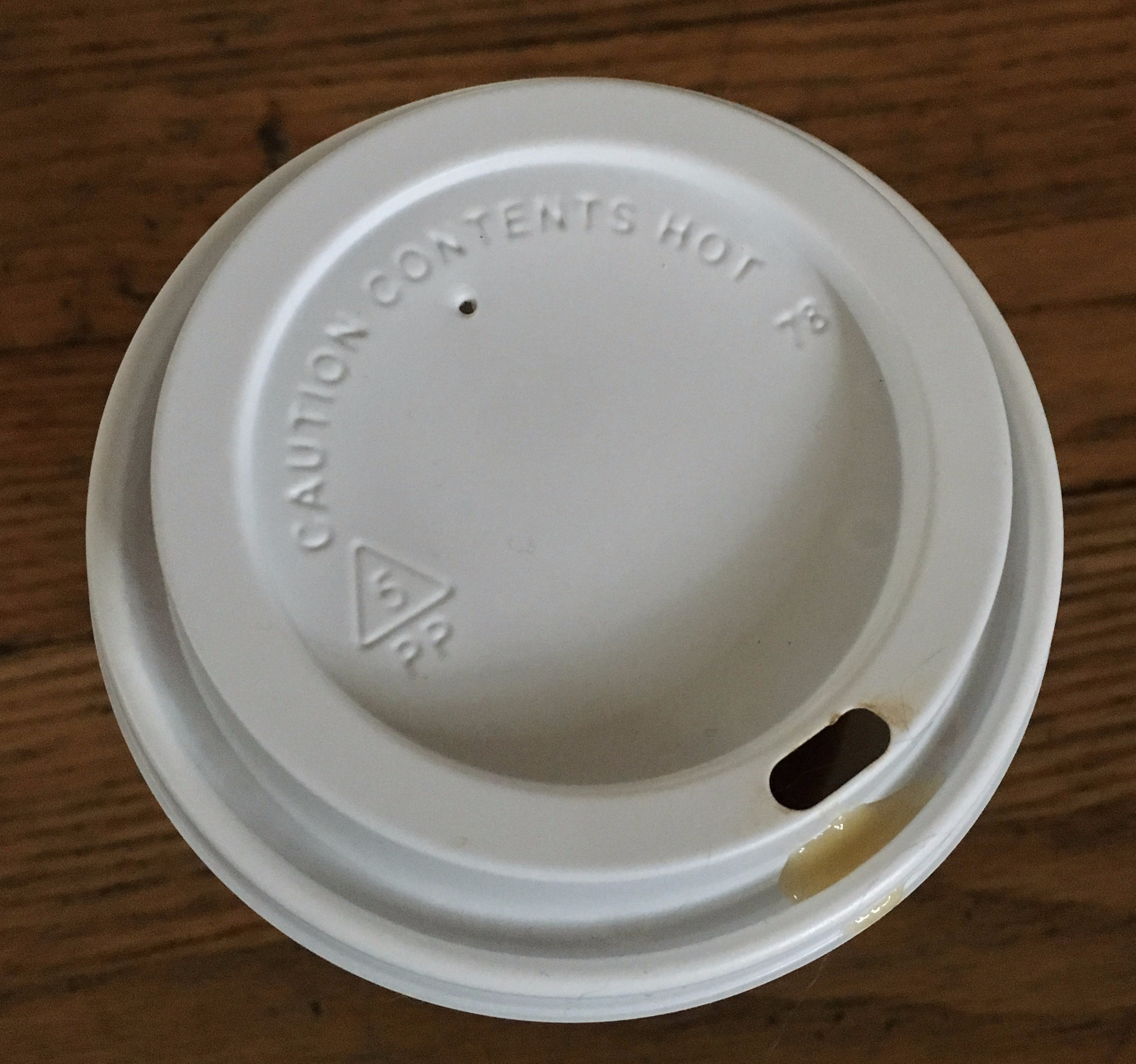 Adult sippy cup lid, with boiling tea seeping over the edge